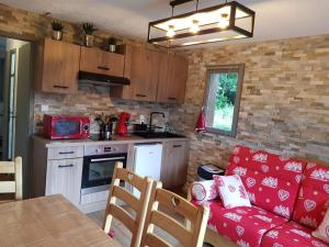 uma sala de estar com um sofá vermelho e uma cozinha em Appartement Saint Gervais les Bains vue imprenable Mont Blanc em Saint-Gervais-les-Bains