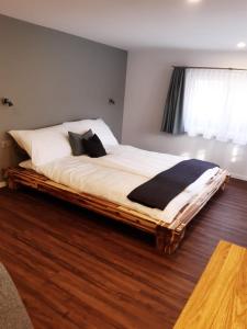 Nesslau的住宿－Gasthaus Gemsli，一间卧室设有一张大床,铺有木地板