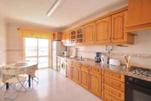 a kitchen with wooden cabinets and a table in it at Prestige For Home - Apartamento T2 - Lagos in Lagos