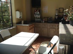 a kitchen with a white table and chairs in it at Executive Inn & Suites in Shepherd