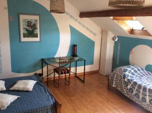 a bedroom with a table and a bed and a desk at les Muriers in Lamastre