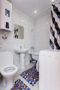 a bathroom with a toilet and a sink and a tub at Apartments at Yemelyanova 35а in Yuzhno-Sakhalinsk
