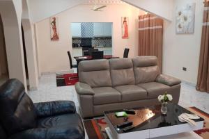 a living room with a couch and a table at The Charming Bristolian Holiday Home in Brusubi