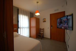 a bedroom with a bed and a flat screen tv at Resort Sitges Apartment Free Parking in Sitges