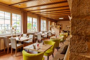 ein Restaurant mit Tischen, Stühlen und Fenstern in der Unterkunft Hotel Ettrich & Elbresort Rathen in Kurort Rathen