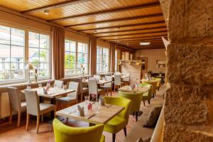 un restaurante con mesas, sillas y ventanas en Hotel Ettrich & Elbresort Rathen, en Kurort Rathen