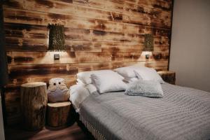 um quarto com uma cama e uma parede de madeira em Foltos Bagoly Vendégház em Bagolyirtás