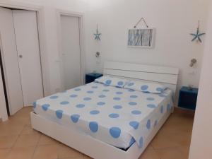 a bedroom with a bed with blue polka dots at La Dimora Del Vento in Marettimo