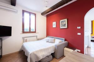 sypialnia z łóżkiem i czerwoną ścianą w obiekcie Valdonica, Bologna by Short Holidays w Bolonii