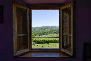 an open window with a view of a balcony at Locanda Vesuna in Pienza