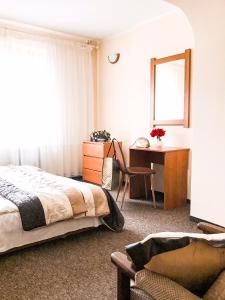 um quarto com uma cama, uma secretária e uma janela em Willa Pod Skocznią em Karpacz