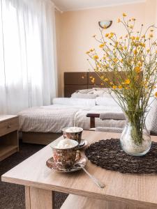 ein Zimmer mit einem Tisch mit zwei Tassen und einer Vase mit Blumen in der Unterkunft Willa Pod Skocznią in Karpacz