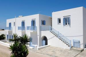 una casa bianca con finestre e scale blu di Stilvi Milos a Plaka Milou