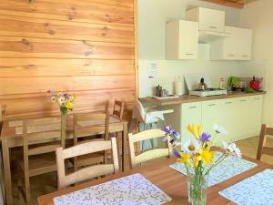 a kitchen and dining room with a table with flowers at Agro-Jaga in Święta Katarzyna