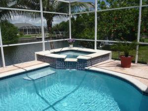 a swimming pool with a hot tub in a yard at Villa Cape Florida in Cape Coral