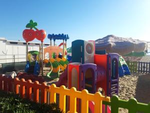 a childrens playground with a fence in the sand at Dolce Brezza in Montesilvano