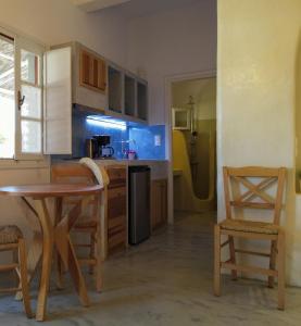 a kitchen with a table and two chairs and a table at Mistral-Patmos in Patmos