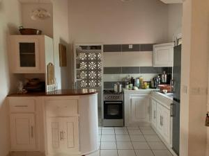 a kitchen with white cabinets and a stove at appartementsurlaplage in Saly Portudal