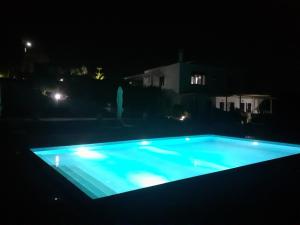 a swimming pool lit up at night at elena in Adamantas +23 photos