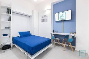 Appartamento incantevole Lido di Ostia- Corallo Azzurro في ليدو دي أوستيا: غرفة نوم بسرير ومكتب وطاولة