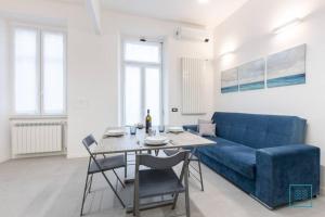 uma sala de estar com um sofá azul e uma mesa em Appartamento incantevole Lido di Ostia- Corallo Azzurro em Lido di Ostia