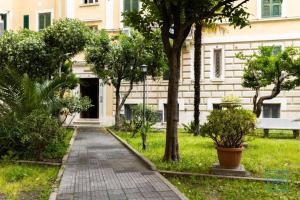 a walkway in front of a building with trees at Appartamento incantevole Lido di Ostia- Corallo Azzurro in Lido di Ostia