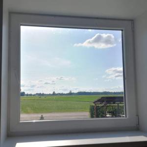 a window in a room with a view of a field at Obinitsa Puhkemaja in Obinitsa