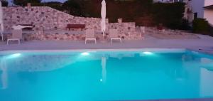 a swimming pool with chairs and a table and a bench at elena in Adamantas
