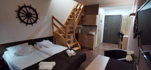 een slaapkamer met een bed en een houten trap bij Dolphin House in Łeba