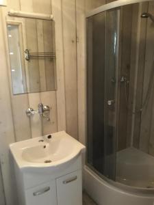biała łazienka z prysznicem i umywalką w obiekcie Camping Anastazja w mieście Międzywodzie