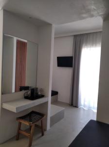 a living room with a table and a mirror at Wabi Luxury Suites & Maisonettes Ios in Ios Chora