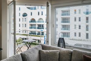 a living room with a couch and a large window at - Maja - Peaceful luxurious appt near the beach in Koksijde in Koksijde
