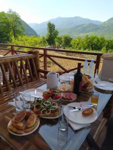 a table with plates of food and bottles of wine at Belvedere in Ambrolauri