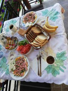 una mesa cubierta con platos de comida en una mesa en Shoposki Guest House, en Elshani