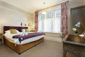 a bedroom with a bed and a desk and a window at Inn in the Park in Bournemouth