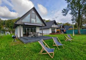 a backyard with chairs and a picnic table and a house at Guest House in Lesko