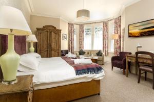 a bedroom with a large white bed and a desk at Inn in the Park in Bournemouth
