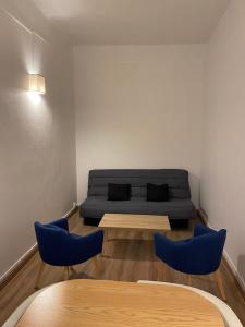 - un salon avec un canapé et deux fauteuils bleus dans l'établissement Studios des Remparts - Avallon, à Avallon