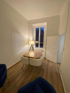 Studios des Remparts - Avallon في أفالون: غرفة معيشة مع طاولة وأريكة ونافذة