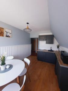 a small kitchen with a white table and chairs at Apartament U Maćków in Murzasichle