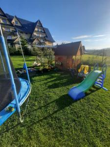 a playground with a slide in the grass at Apartament U Maćków in Murzasichle