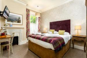 a bedroom with a large bed and a fireplace at Inn in the Park in Bournemouth