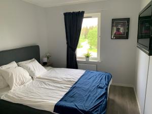 een slaapkamer met een groot bed en een raam bij Rämsbyns fritidsby in Idkerberget