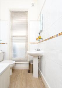 a white bathroom with a sink and a mirror at Inn in the Park in Bournemouth