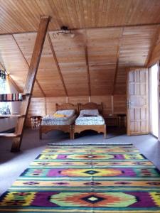 a room with two beds and a rug on the floor at Guest House Mansarda in Yaremche