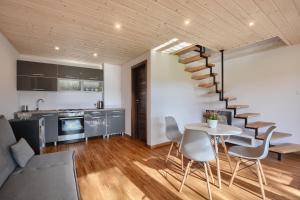 a living room with a staircase and a table and chairs at Guest House in Lesko