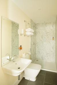 a white bathroom with a sink and a toilet at Springkell in Eaglesfield