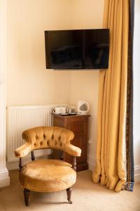 een woonkamer met een stoel en een televisie bij Springkell in Eaglesfield