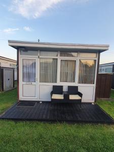 a gazebo with two chairs on a deck at Lovely Relaxing two bedroom Holiday Chalet in Skegness