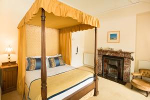 a bedroom with a canopy bed and a fireplace at Springkell in Eaglesfield